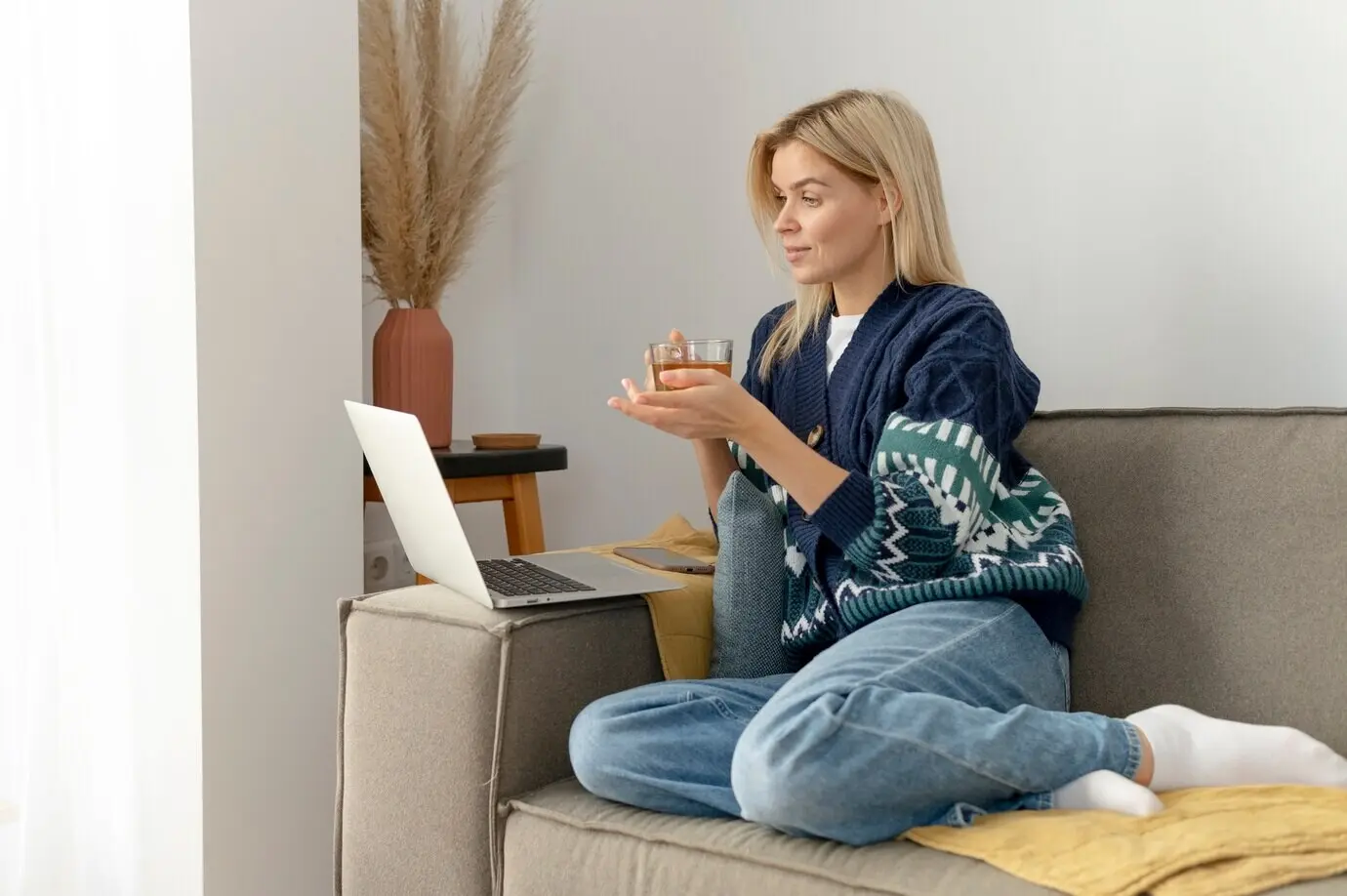 Full-body shot of a woman sitting on a couch